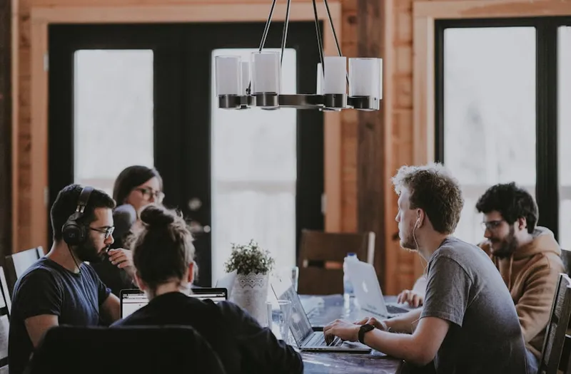 Une petite équipe travaille ensemble autour d'une table d'ordinateurs portables